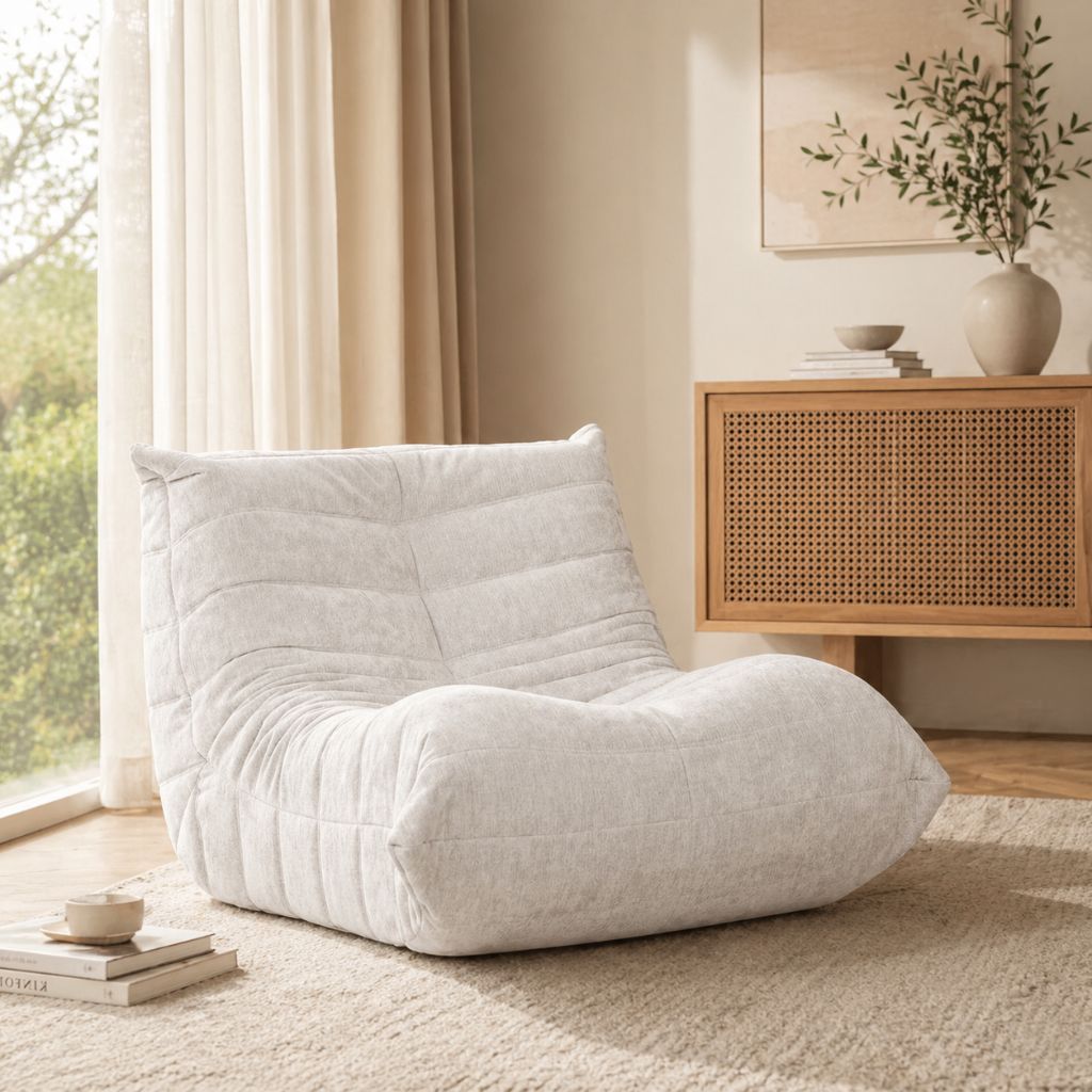 White bean bag chair in a cozy living room with a wooden cabinet and plants.