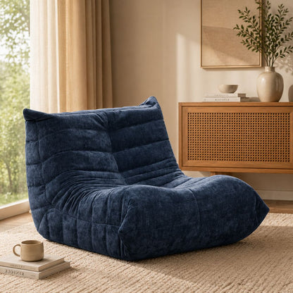 Blue bean bag chair in a room with a window, books, and a plant.